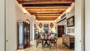 A dining area with a wooden ceiling, a round table, and chairs. - Trastevere Outstanding 4 Br Terraced Apartment (Rome)
