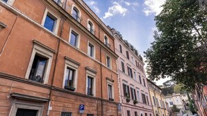 A multi-story building with classic architecture, featuring arched windows and balconies. - Trastevere Outstanding 4 Br Terraced Apartment (Rome)