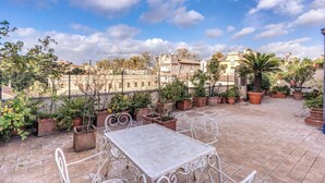 A rooftop terrace with potted plants, a metal table, and chairs. - Trastevere Outstanding 4 Br Terraced Apartment (Rome)