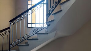 A staircase with ornate black railings and a stained glass window at the bottom. - Vatican Beautiful 2Br Apartment  (Rome)
