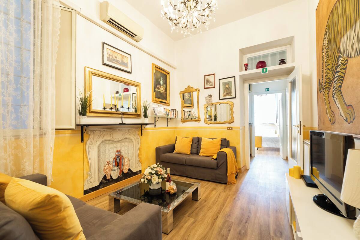 A living room with a fireplace, a sofa, a coffee table, and a television.