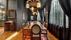 A long dining table with chairs, wooden walls, and a chandelier. - Iconic Mansion w/Private Pool & Spa, Walk Downtown (New Orleans)