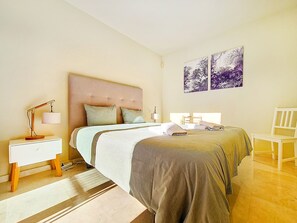 A hotel room with a large bed, a bedside table with a lamp, a chair, and two wall-mounted artworks. - Beach location, wifi, parking, communal pool (Los Alcazares)