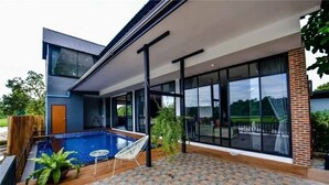 A modern house with a swimming pool, large windows, and a covered patio area. - Brick Box Pool Villa & Café (Doi Saket)