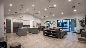 A spacious kitchen with a central island, a dining area with a table and chairs, and a living area with a sofa and ottoman. - Top-Notch Villa in Central Scottsdale (Scottsdale)