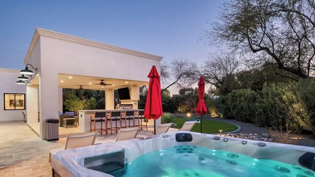 A modern outdoor hot tub area with a bar and seating, surrounded by greenery. - Top-Notch Villa in Central Scottsdale (Scottsdale)