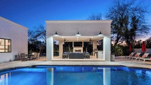 A swimming pool with a covered patio area, outdoor furniture, and a view of the surrounding landscape. - Top-Notch Villa in Central Scottsdale (Scottsdale)