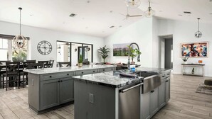A spacious kitchen with a large island, modern appliances, and pendant lighting. - Top-Notch Villa in Central Scottsdale (Scottsdale)