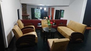 Ein Zimmer mit einer Sofagarnitur, einem kleinen runden Tisch und einer Vase mit Blumen.