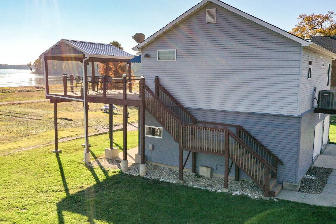 A two-story house with a covered patio and a staircase leading to the upper level.