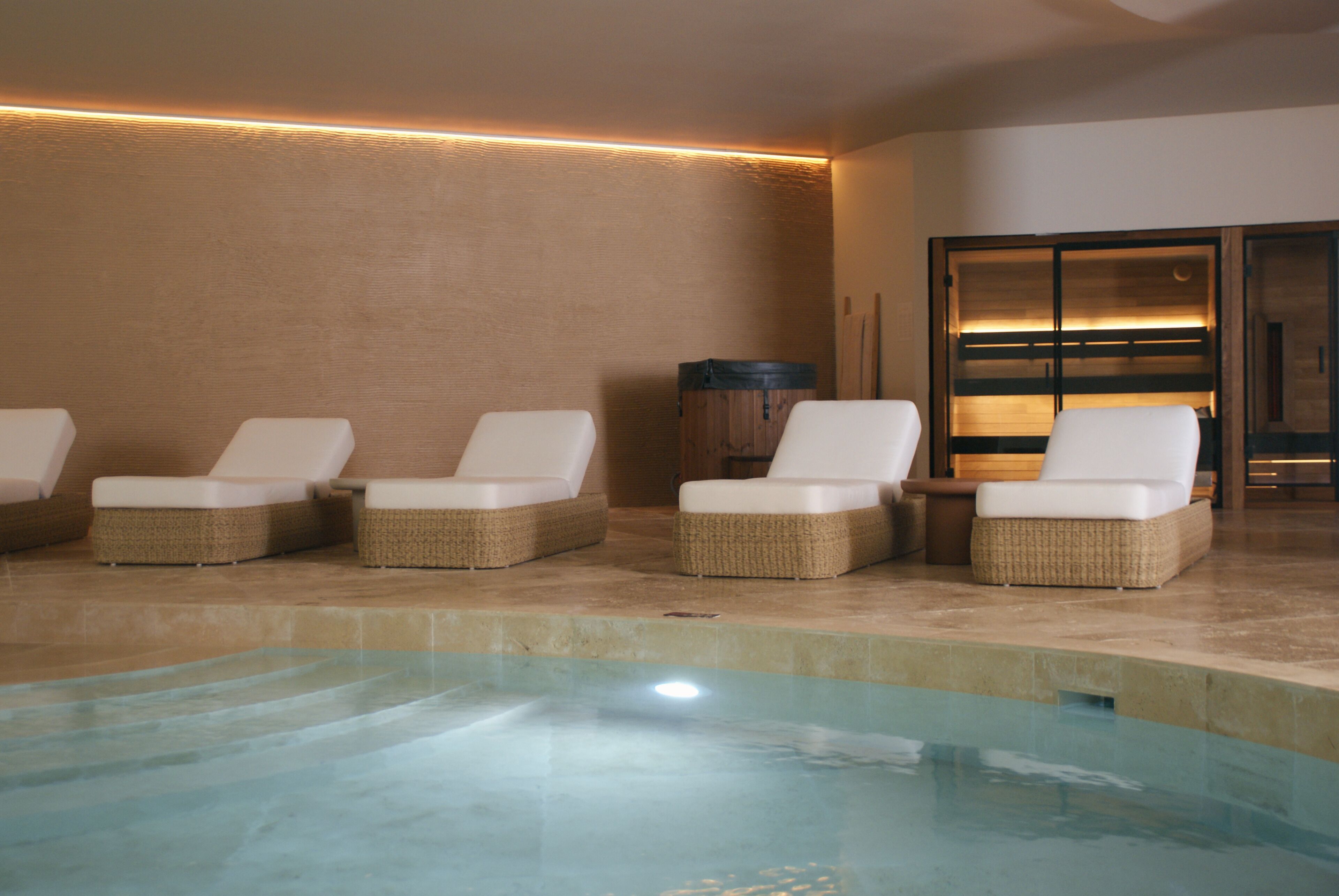 Un espace piscine avec des chaises longues et un tonneau en bois.