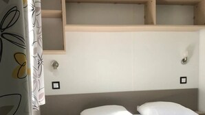 Ein Schlafzimmer mit einem Bett, einem Kopfteil und Regalen über dem Bett.