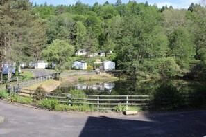 A lakeside property with cabins, a wooden fence, and a road.