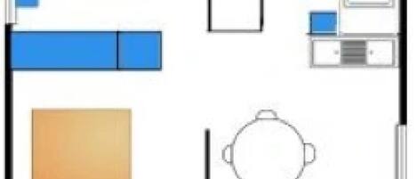 A hotel room layout with a bed, a desk, a chair, a small table, and a bathroom area.