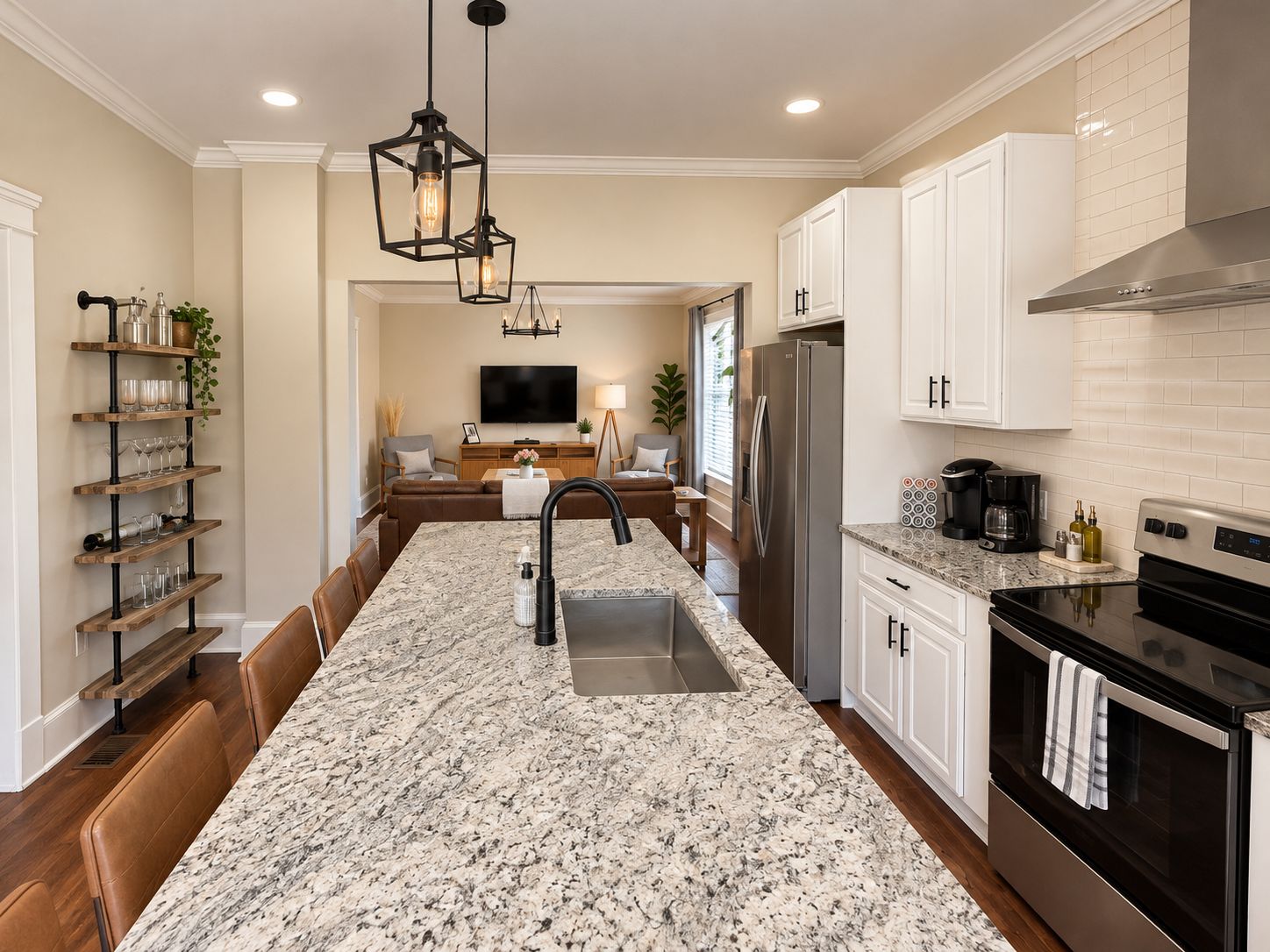 A modern kitchen with a central island, stainless steel appliances, and a dining area with a sofa and table.