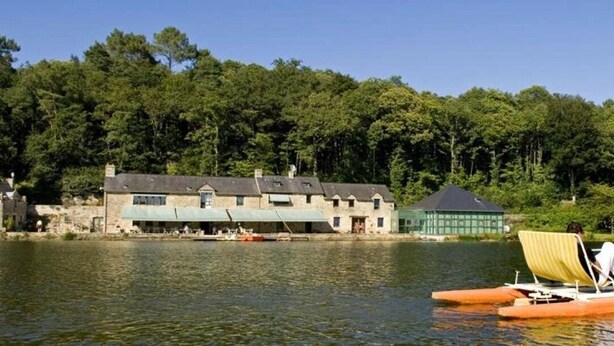 Un bâtiment situé au bord du lac, avec un quai et un canot.