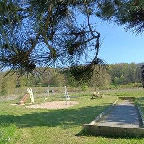 A park with a playground, picnic table, and a wheelchair-accessible path.