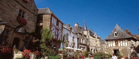 A cobblestone street lined with historic buildings, some with visible signage.