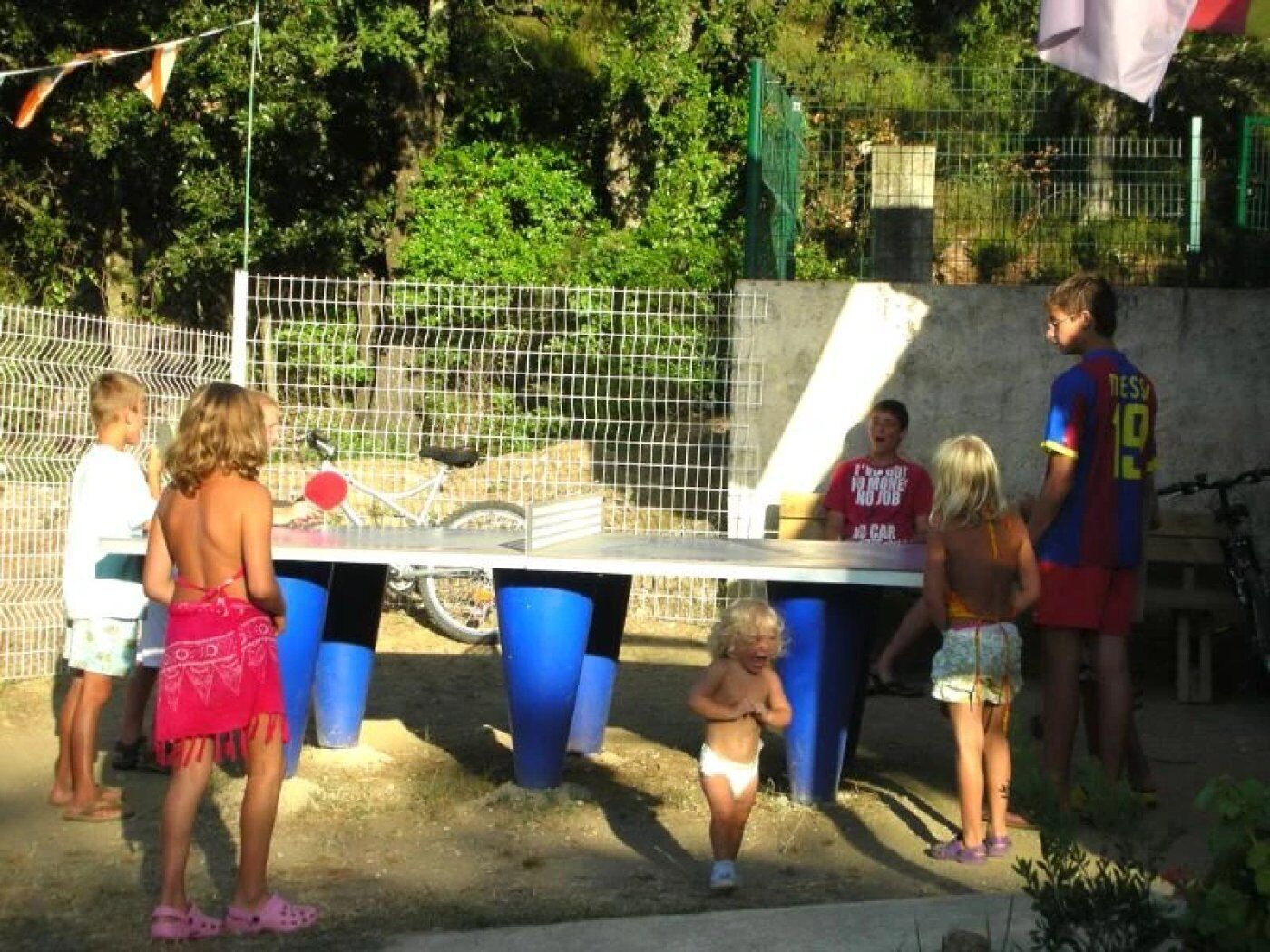 Een groep mensen speelt buiten tafeltennis.