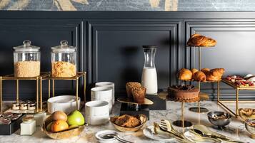 Un ricco buffet per la colazione con dolci, frutta e salse varie.