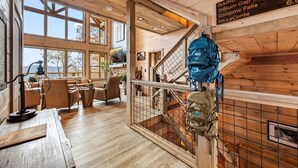 A cabin interior with a wooden interior, a staircase, and a sign indicating the Rainbow Falls Trail distances. - Top 1%, Pickleball, Sauna, Hot Tub, Near Dollywood (Sevierville)