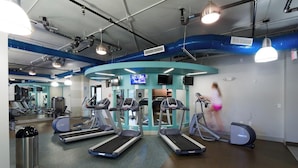 A gym with treadmills, elliptical machines, and a mirrored wall. - Landing | Stunning Studio, Pool, Gym (Atlanta)