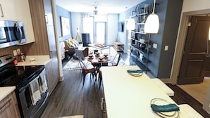 A modern kitchen with a dining area, a built-in oven, and a microwave. - Landing | Stunning Studio, Pool, Gym (Atlanta)