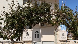 A modern building with a stone facade, two balconies, and a clear sky. - Michelle Apartments (Ksamil)