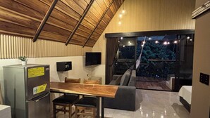 Une cuisine moderne avec une table et des chaises en bois, un réfrigérateur et un téléviseur fixé au mur.