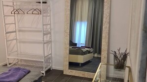 A bedroom with a bunk bed, a wardrobe, a mirror, and a small table with a vase. - Be Magenta Art Home - Yellow style (Magenta)
