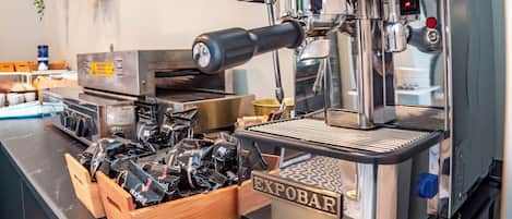 Una cafetera con pantalla digital, depósito de agua y molinillo de café.