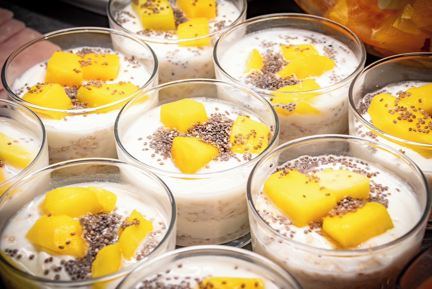 A selection of dessert bowls with mango chunks and chia seeds.