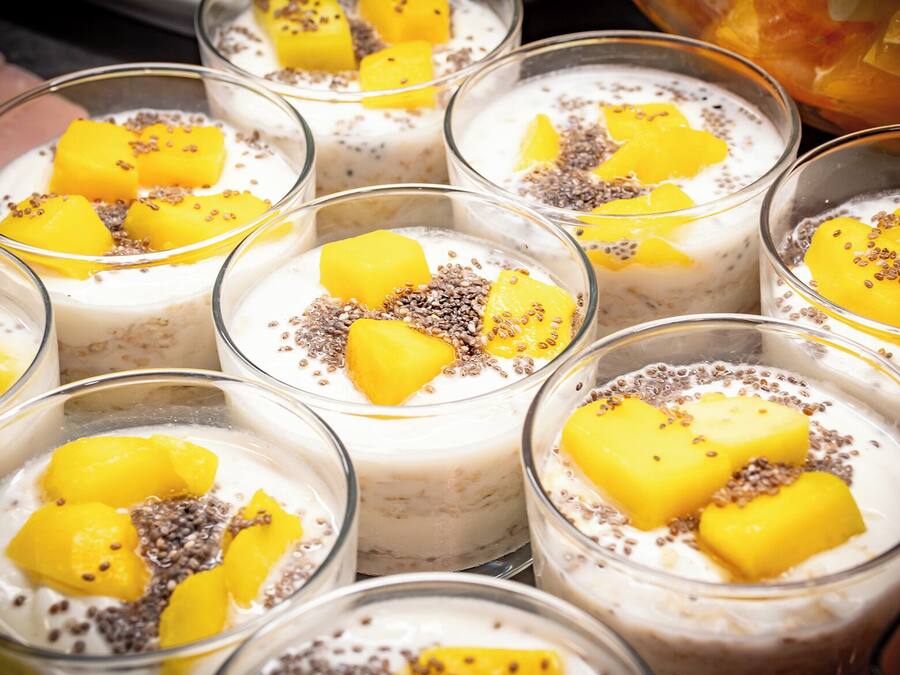 A selection of dessert bowls with mango chunks and chia seeds.
