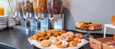 A breakfast buffet with various food items and a coffee station.