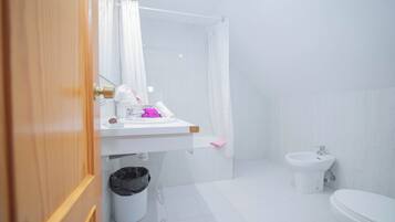 A bathroom with a sink, toilet, and shower.