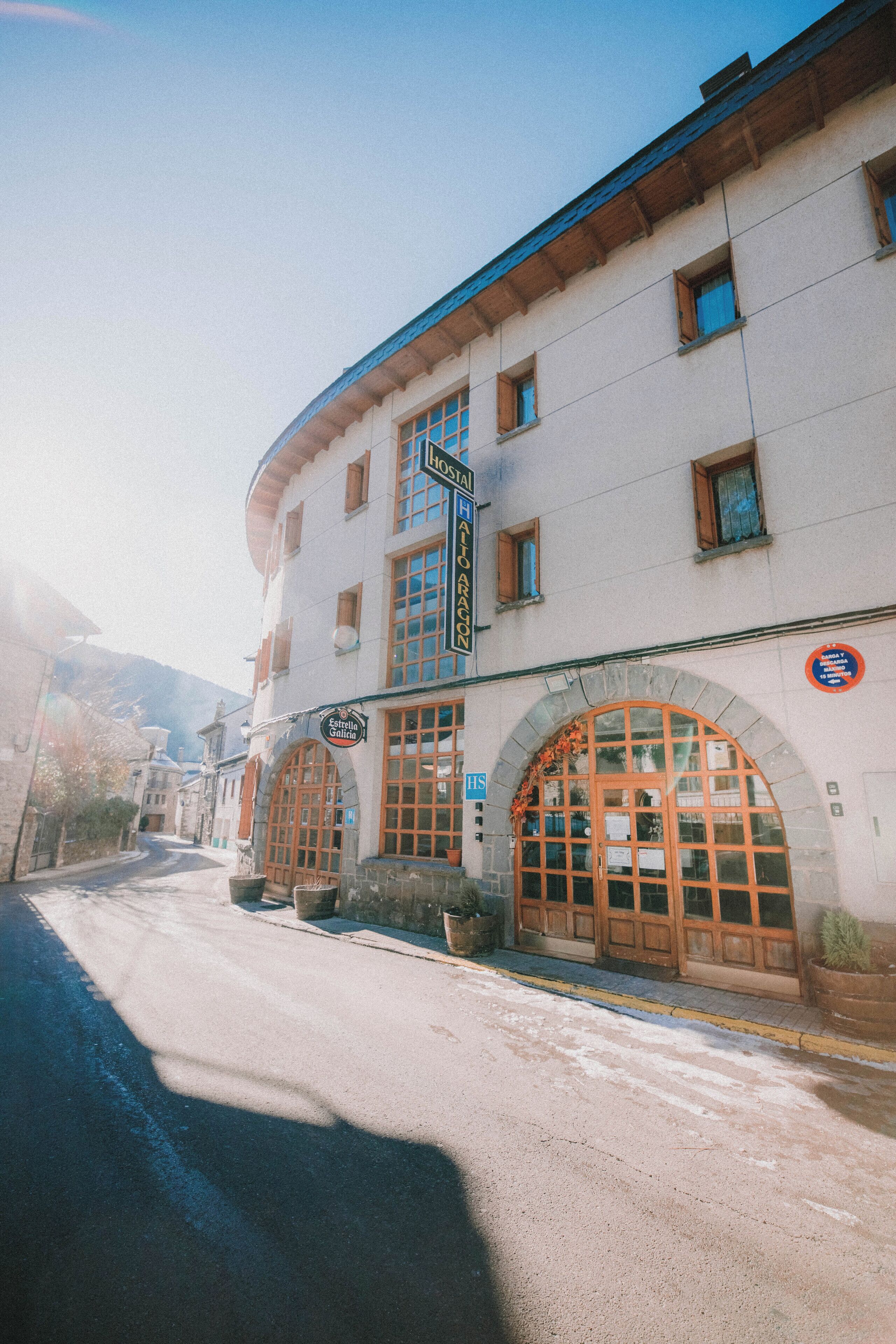 Un edificio con una amplia entrada en arco, varias ventanas y un letrero que indica que es un hotel.