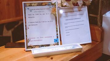 A wooden table with a framed sign and a vase of white orchids.