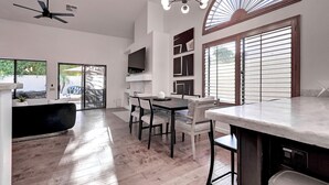 A modern kitchen with a dining area, large windows, and a ceiling fan. - 5 Bdrm Entertainers Dream Home.  Game Room, HTD Pool and Backyard Oasis! (Scottsdale)