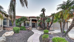 A residential property with a curved driveway, palm trees, and a stone pathway. - 5 Bdrm Entertainers Dream Home.  Game Room, HTD Pool and Backyard Oasis! (Scottsdale)