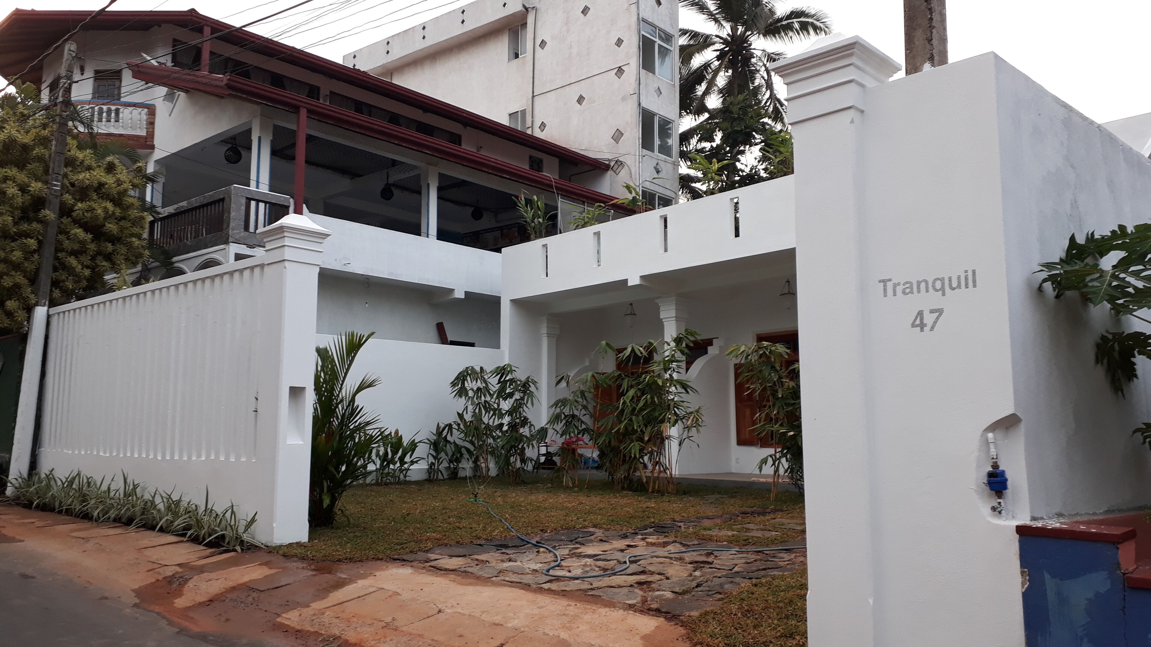 A white building with a balcony and a number '47' on the side.