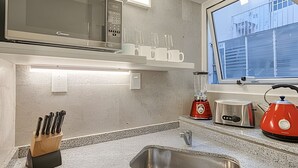A kitchen with a stainless steel sink, a red blender, a toaster, and a knife block. - Spacious with Terrace and Private BBQ in Belgrano (Buenos Aires)