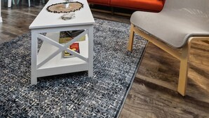 A modern living room with a blue accent wall, a red sofa, a white coffee table, and a grey armchair. - Prime 1BD Close to the Action (Arlington)