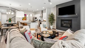 A modern living room with a sofa, coffee table, and fireplace. - Joyous 3BDTownhouse:  UltraCool & Spacious! (Fort Worth)