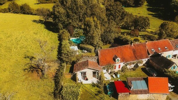 An aerial view of a rural area with houses, a swimming pool, and a large tree. - Dordogne - Beautiful cottage for 8 with a pool (Saint Rabier)