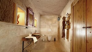 A narrow hallway leading to a bathroom with a sink, toilet, and a mirror. - Double Room with Spa Bath (Uchisar)