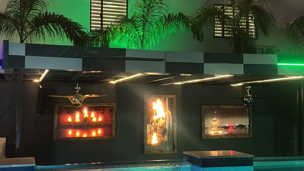 A pool area with a water feature, palm trees, and ambient lighting. - Lunar Signature Hotel & Suites  (Enugu)