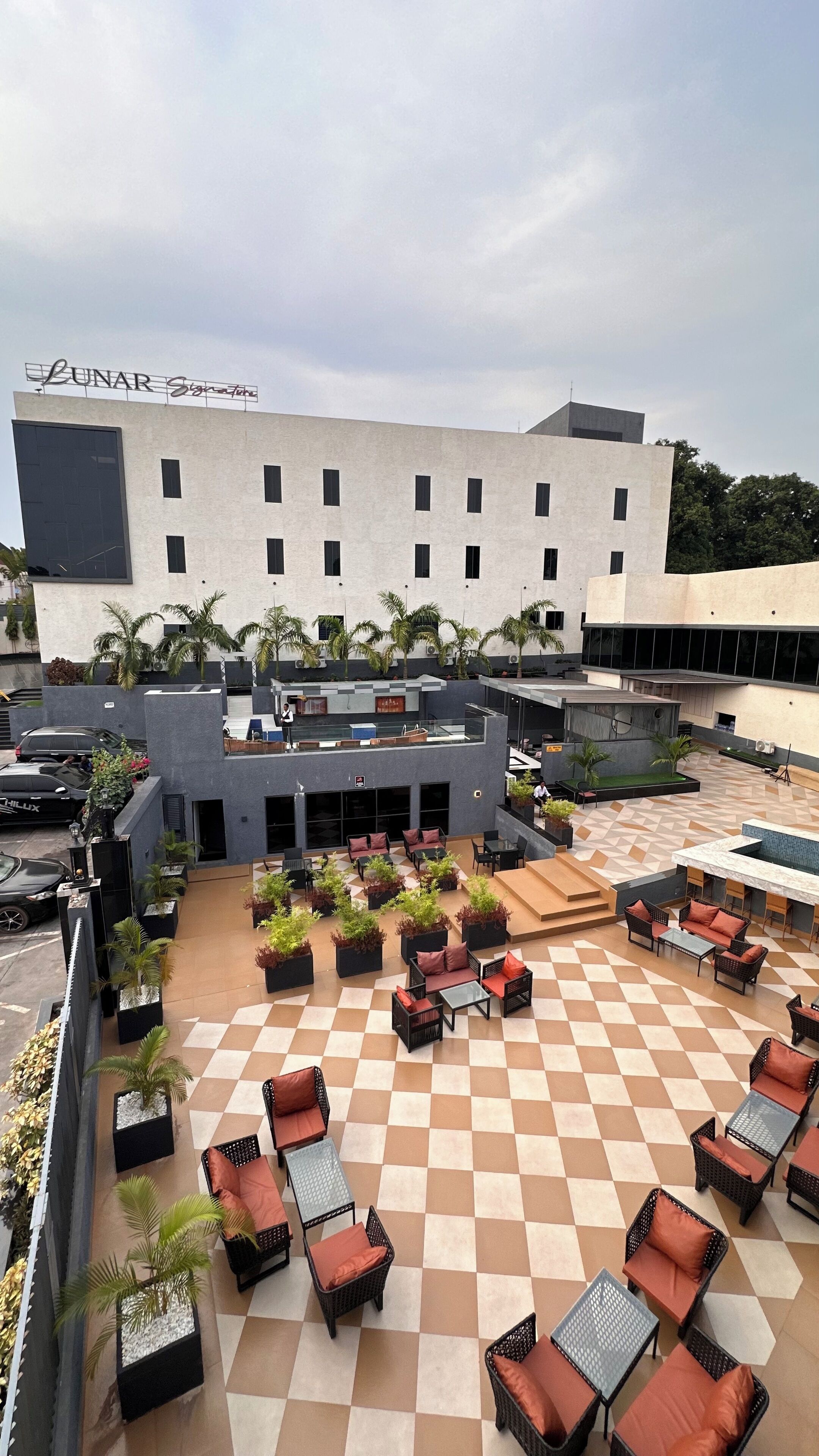A rooftop patio area with outdoor seating and a building in the background.