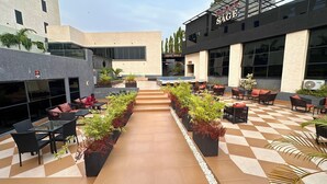 An outdoor patio area with seating arrangements and potted plants. - Lunar Signature Hotel & Suites  (Enugu)