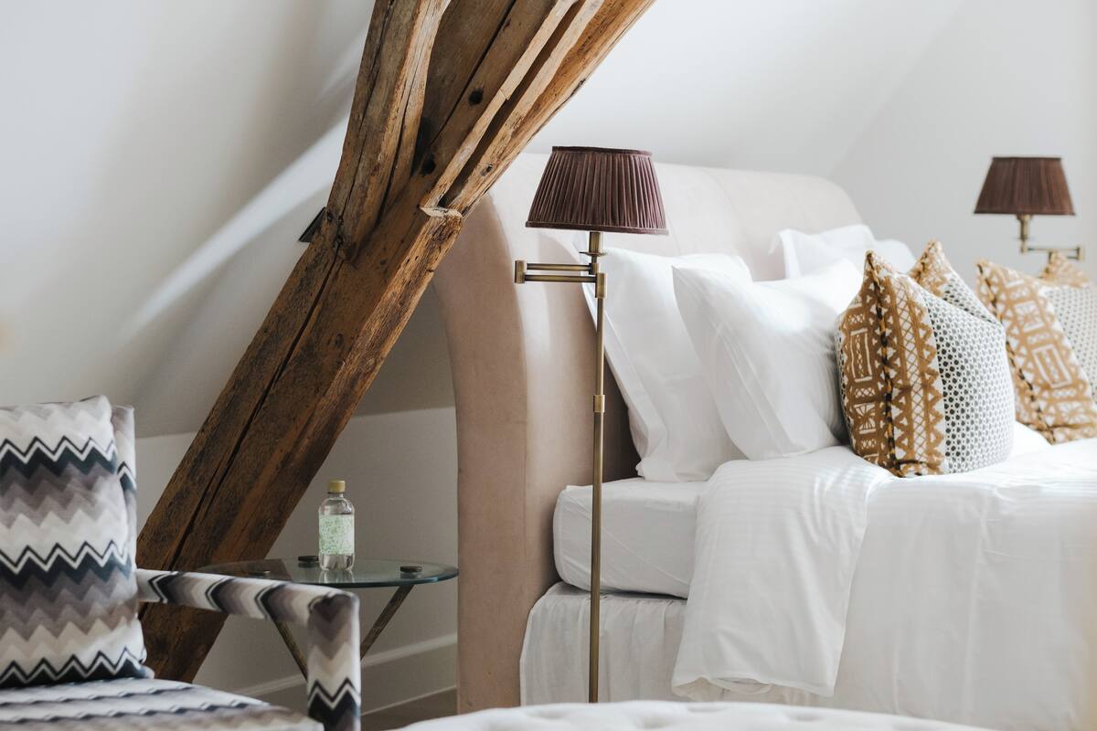 A bedroom with a bed, bedside tables, a lamp, and a chair.