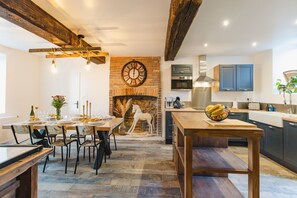Enjoy meals in this charming kitchen and dining area, featuring an oven and stainless steel range hood.